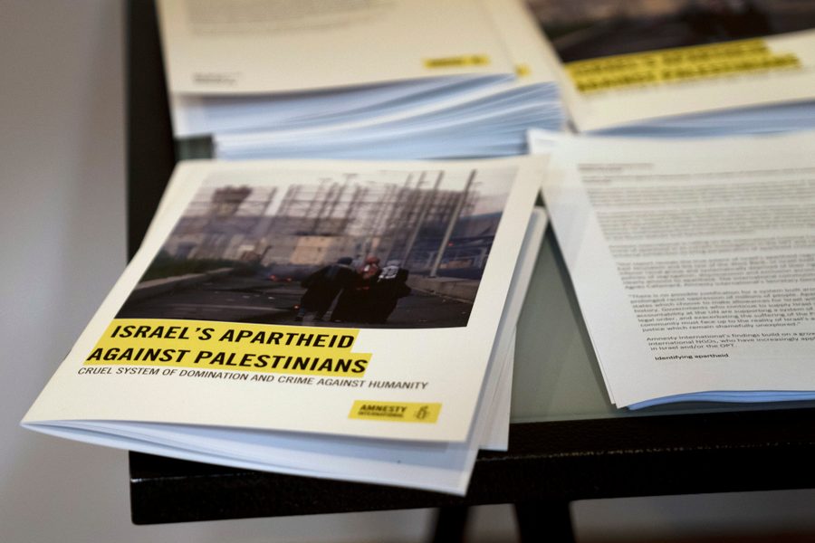 Photo of printed copies of Amnesty International's report on a table.